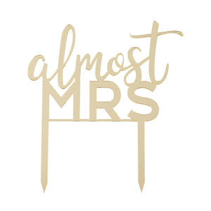 gold acrylic cake topper that reads "almost mrs" 
